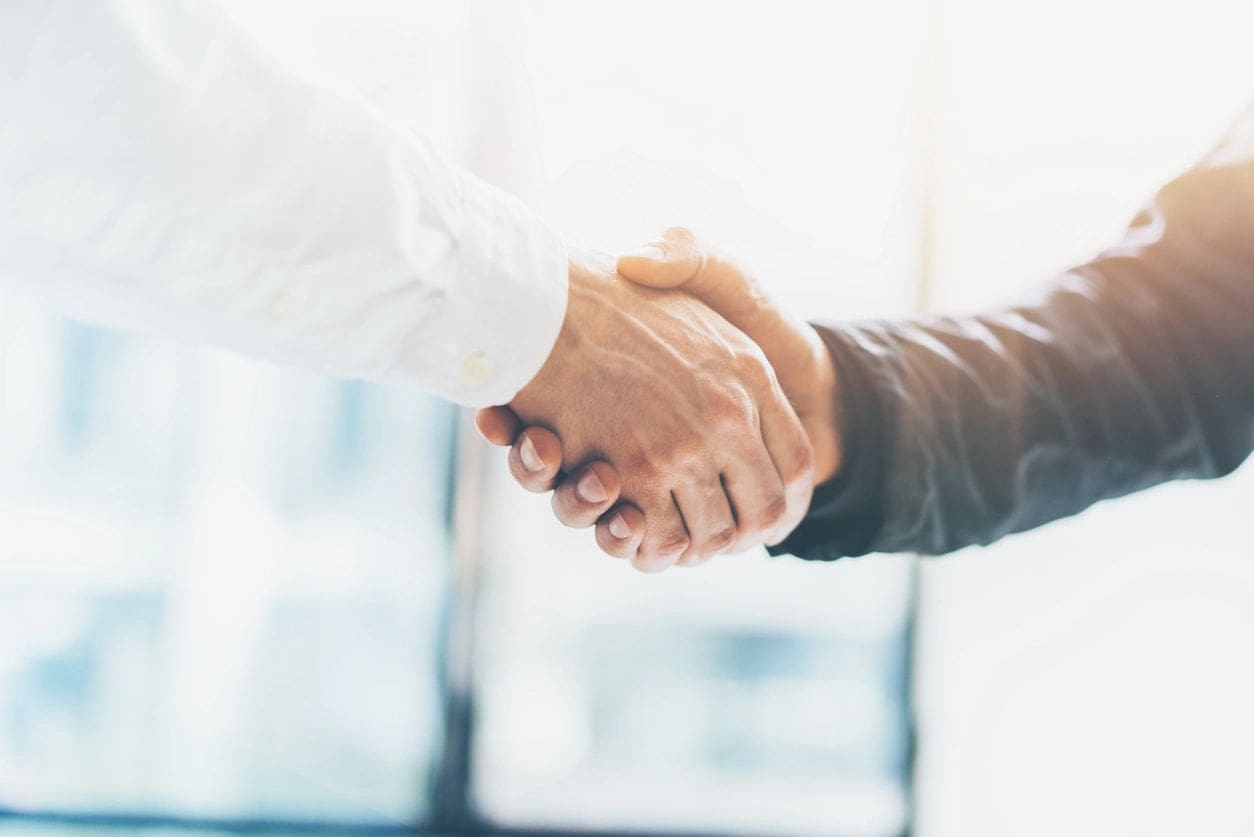 Two people shaking hands in a room.