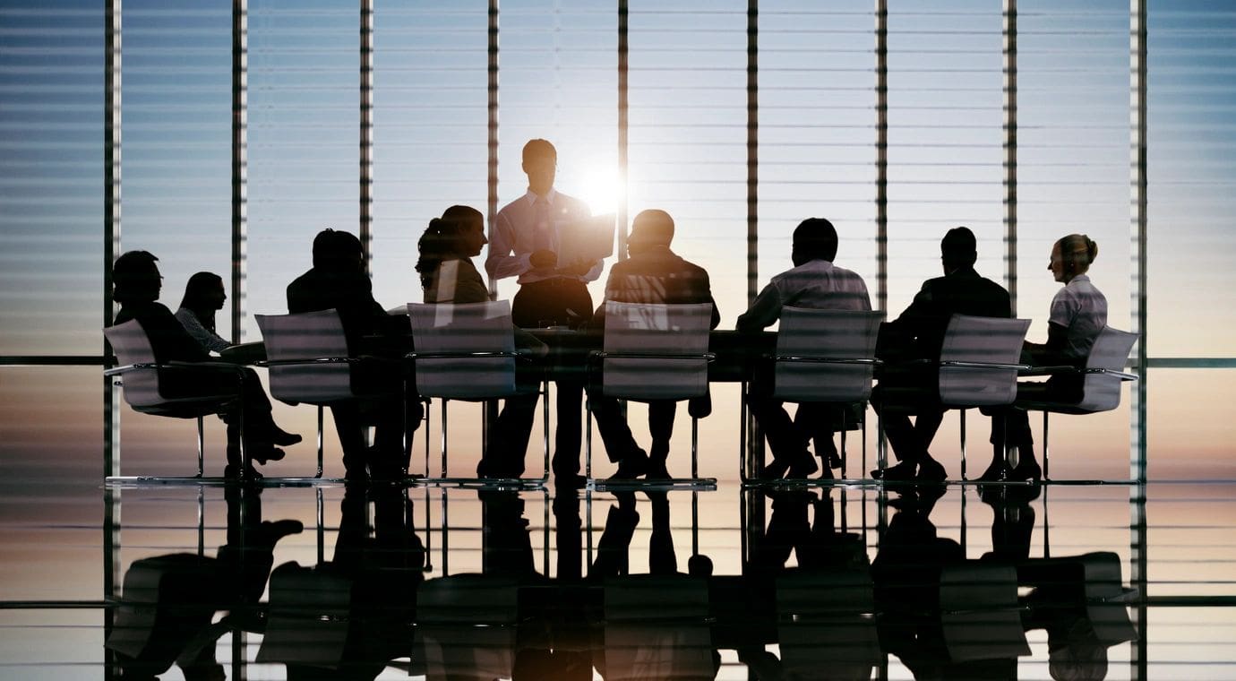 A group of people sitting at a table in front of the sun.